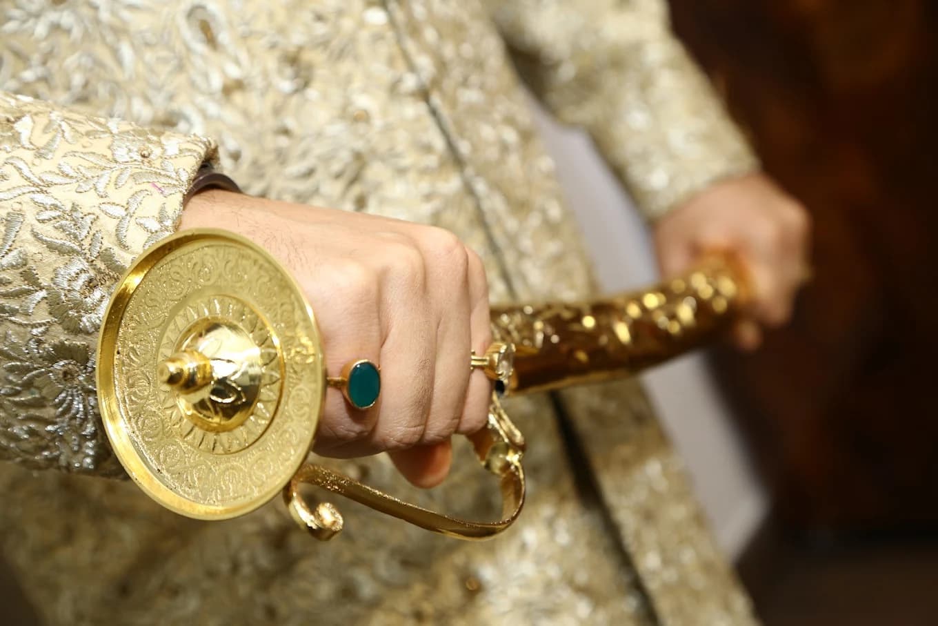 Groom holding ceremonial gold sword